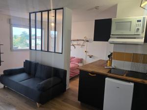 a living room with a couch and a microwave at Appartement Lovely in Muret