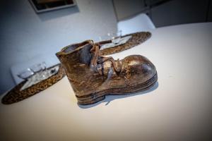 Ein alter Schuh liegt auf einem Tisch neben einem Gürtel. in der Unterkunft Petit Câlin - Le Four des Alpes in Rhemes-Saint-Georges + 20 Fotos