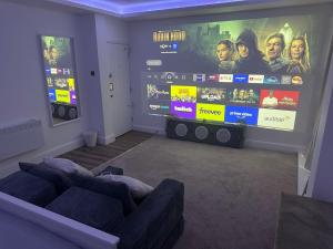 a living room with two couches and a large screen at Cinema room apartment 2 in Basildon