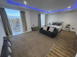a bedroom with a bed and a couch and a window at Cinema room apartment 2 in Basildon
