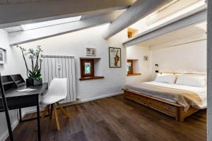 ein Schlafzimmer mit einem Bett, einem Schreibtisch und einem Computer in der Unterkunft Petit Câlin - Le Four des Alpes in Rhemes-Saint-Georges