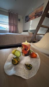 a candle on a rock with fruit on a bed at Sleep with the stars in Oslo