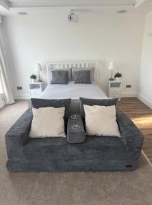 a bedroom with a large bed with pillows at Cinema room apartment 2 in Basildon