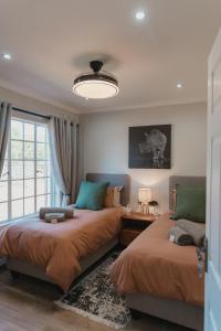 a bedroom with two beds and a window at Welverdiend - Unit 1 in Bloemfontein