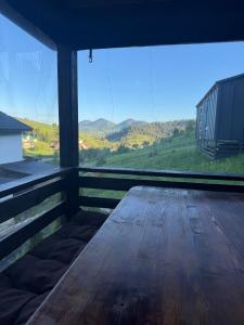 a wooden bench on a porch with a view at Подих Карпат in Volosyanka