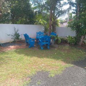 two blue chairs and a table in a yard at Hiri Relax Hostal in Dickwella +7 photos