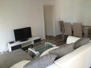 uma sala de estar com um sofá e uma televisão de ecrã plano em L&L Lodge Günding em Günding