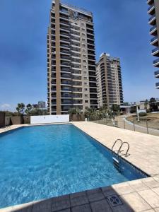 une piscine avec deux grands immeubles en arrière-plan dans l'établissement Temporary Furnished Apartment 1 bedroom, à Córdoba