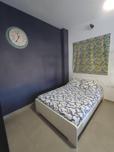 a bedroom with a bed and a clock on the wall at Casa Fede Los Abrigos in Los Abrigos