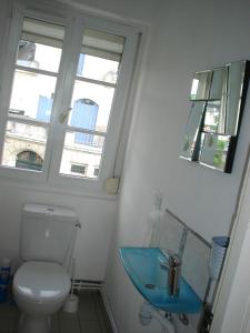 La salle de bains est pourvue de toilettes et d'un lavabo bleu. dans l'établissement Gite "Etape à Coucy", à Coucy-le-Château-Auffrique