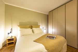 ein Schlafzimmer mit einem weißen Bett mit einem Buch darauf in der Unterkunft Lo Micho - Le Four des Alpes in Rhemes-Saint-Georges