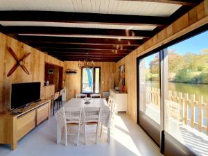 a dining room with a table and a large window at Chalet au bord d'un lac privé in Saint-Estèphe
