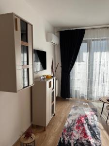Una sala de estar con un armario blanco y una ventana. en Focsani Studio Residence 2, en Focşani