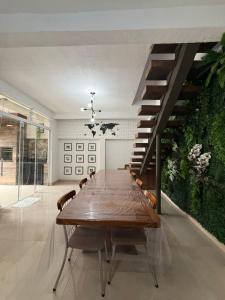 ein Esszimmer mit einem Tisch und einer Treppe in der Unterkunft Casa Quintal de Bertioga Centro in Bertioga