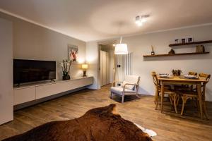 ein Wohnzimmer mit einem TV und einem Esstisch in der Unterkunft La Tsambra-Le Four des Alpes in Rhemes-Saint-Georges