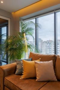 a brown couch in a room with a large window at Renest New York Skyline View in Chişinău