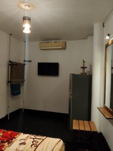 Una habitación con una cama y un televisor. en Sihe House, en Gintota