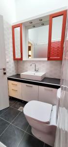 a bathroom with a white toilet and a sink at Harmony Apartment Pythagoreio Samos Center in Pythagoreio
