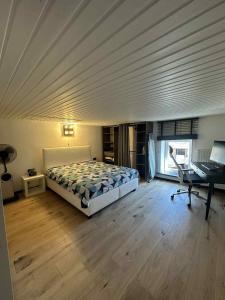 een slaapkamer met een bed, een bureau en een computer bij Le Mas d 'Ecaussinnes in Écaussinnes-dʼEnghien