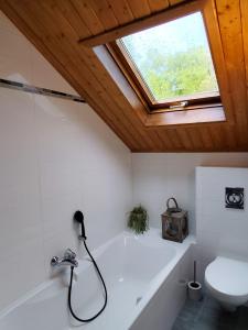 a bathroom with a bath tub and a window at Holiday Home Le Holset in Durbuy