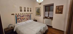 ein Schlafzimmer mit einem weißen Bett und einem Fenster in der Unterkunft La Terrazza 2P Rooms in Abbadia San Salvatore