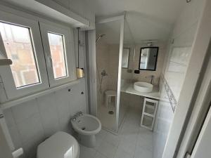 Un baño blanco con inodoro y lavabo. en A casa di Meri, en Roma 9 fotos más