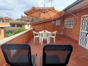Un patio con una mesa y sillas y una sombrilla. en A casa di Meri, en Roma