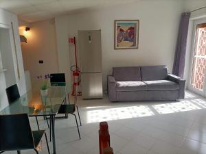 Una sala de estar con un sofá y una mesa de cristal. en A casa di Meri, en Roma