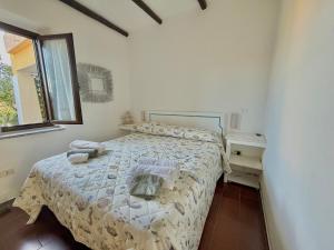 a white bedroom with a bed and a window at La Casa al Mare in Cannigione