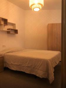 a bedroom with a bed and a chandelier at coparelia 2 in Villarrobledo