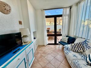 a living room with a couch and a flat screen tv at La Casa al Mare in Cannigione