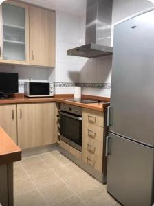 a kitchen with a white refrigerator and wooden cabinets at coparelia 2 in Villarrobledo