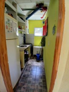 eine Küche mit einem Kühlschrank und Fliesenboden in der Unterkunft El Jardin de Sauce in Monte Hermoso + 42 Fotos