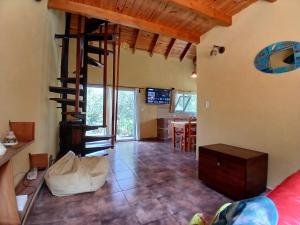 ein Wohnzimmer mit einer Wendeltreppe und einem Esszimmer in der Unterkunft El Jardin de Sauce in Monte Hermoso