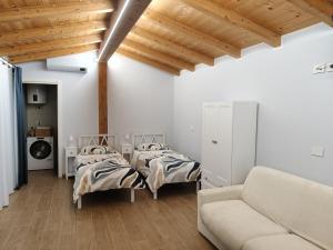 a living room with two beds and a couch at Iris Cottage in Anzola dell'Emilia