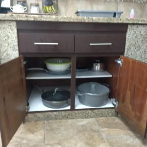 a kitchen cabinet with pots and pans in it at Daisy'Hause 2 to 6 people, ideal for your family in Carolina +21 photos