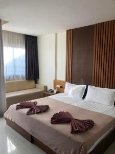 ein Schlafzimmer mit einem großen Bett mit Bögen darauf in der Unterkunft Baan KetKaew GuestHouse 1 in Patong Beach