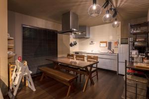 a kitchen with a table and chairs in a room at Noctis豊田 ジャグジー肩湯付お風呂75型TV 最大12名宿泊可能 in Toyota