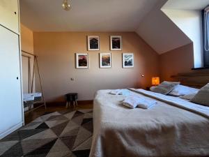 a bedroom with two beds and pictures on the wall at Apartmán Juli in Tatranská Lomnica
