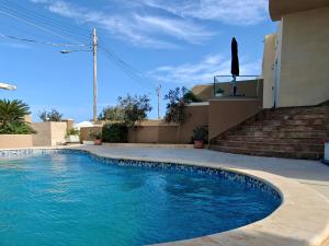 a swimming pool in front of a house at Private Flatlet in a Villa with Pool - 6 Guests Max in Naxxar