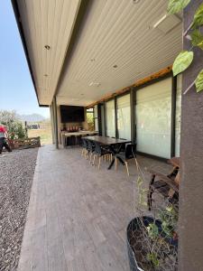 a patio with a table and chairs and a television at Loft moderno con cocina americana y vistas a la montaña in Belén