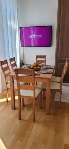 a dining room table with chairs and a television on the wall at Harmony Apartment Pythagoreio Samos Center in Pythagoreio