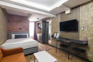 a hotel room with a bed and a flat screen tv at Nomad Hub Suit İstanbul in Istanbul