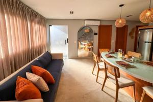 een woonkamer met een blauwe bank en een tafel bij MHV Milagres - Lanaí 30 Refúgio próximo a Praia a poucos metros da Praia e da Capela dos Milagres in São Miguel dos Milagres