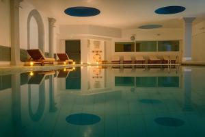 a swimming pool with chairs and a clock on the wall at Panorama Apartment in Trieste