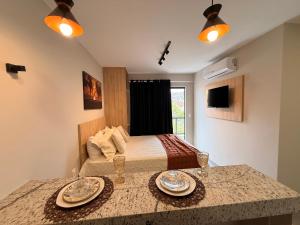 a bedroom with a bed with two plates on a counter at Suítes da Grazi - Centro Arraial do Cabo in Arraial do Cabo