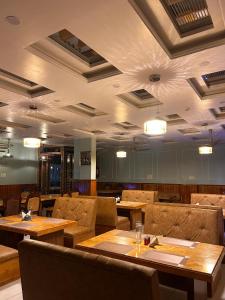 a restaurant with wooden tables and brown chairs at The Satluj Vista in Bilāspur