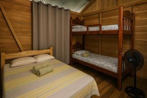 a bedroom with two bunk beds and a fan at Cabin -Treehouse La Tigra in San Gerardo