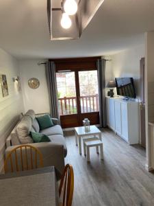 a living room with a couch and a table at Chalets des Evettes- appartement vue montagne in Flumet