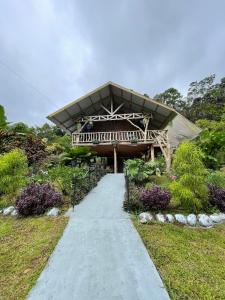 a walkway leading to a building with a roof at Cabin -Treehouse La Tigra in San Gerardo